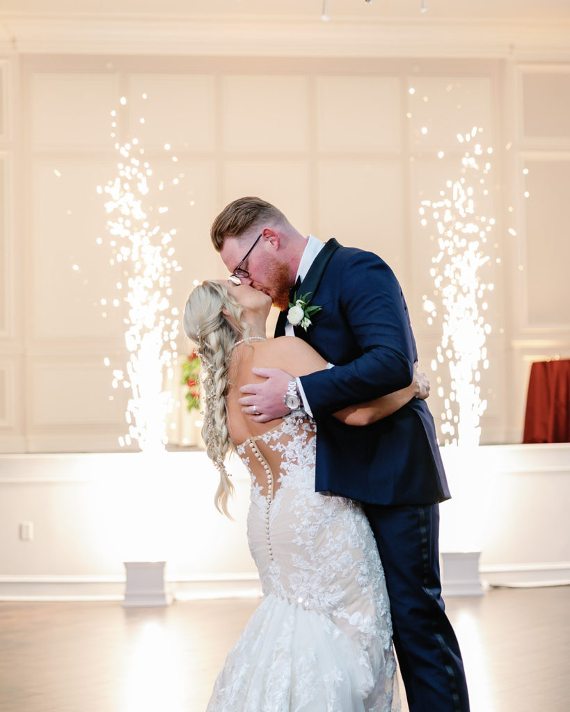 Wedding couple kiss in front of indoor sparklers