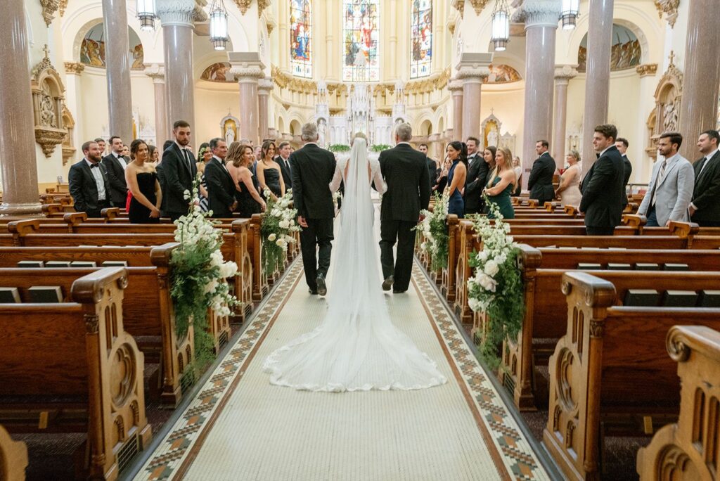 bride walks down the aisle at Sacred Heart Tampa